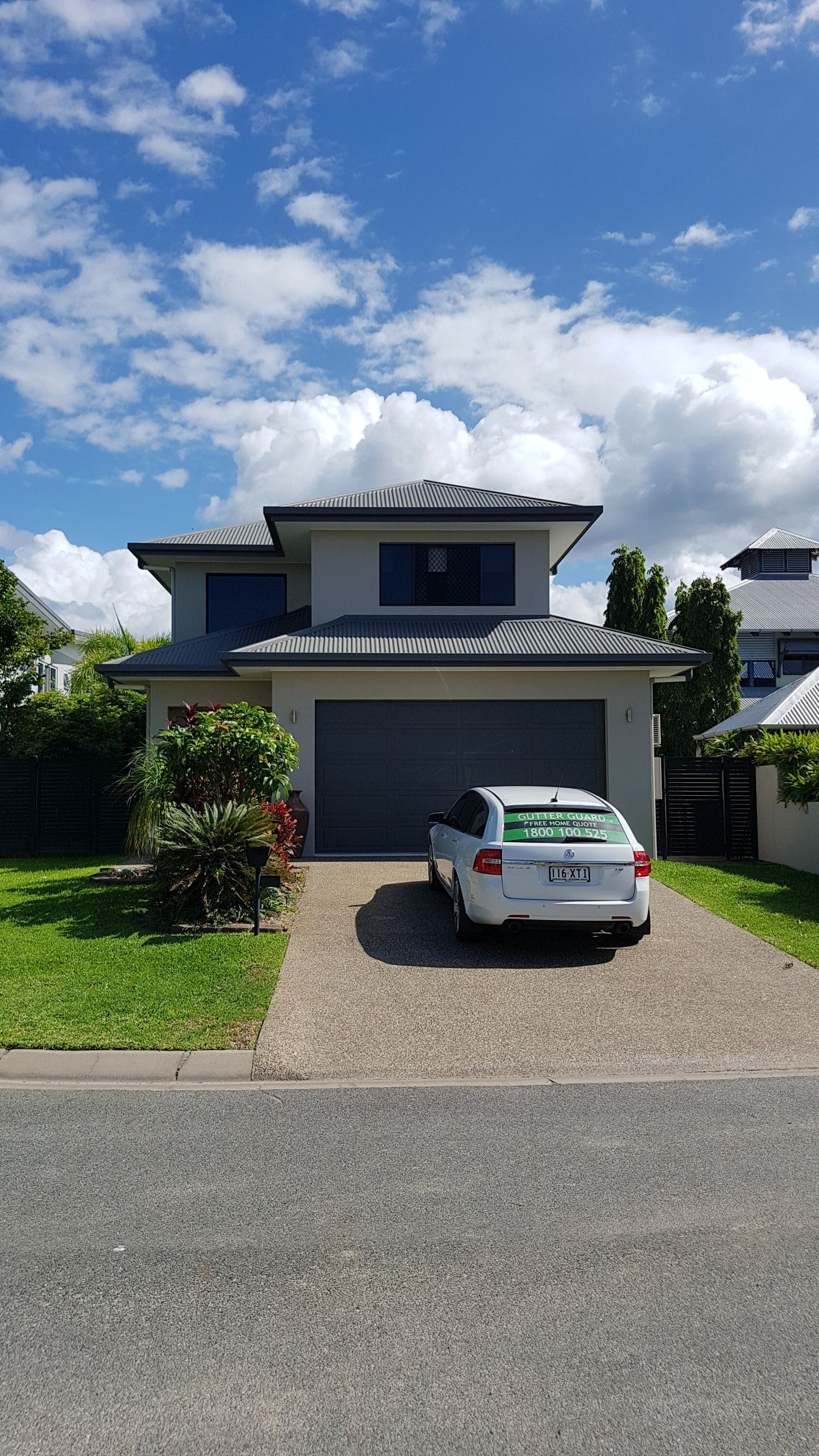 Two-Story House with Gray Roof and Garage Door — All-Clear Gutter Guard NQ in Malanda, QLD