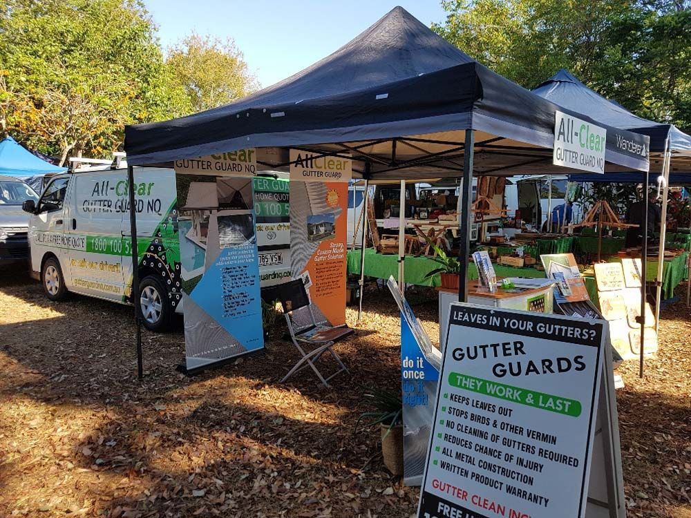 A Vendor Booth with A Black Canopy Advertising Gutter Guards — All-Clear Gutter Guard NQ in Herberton, QLD