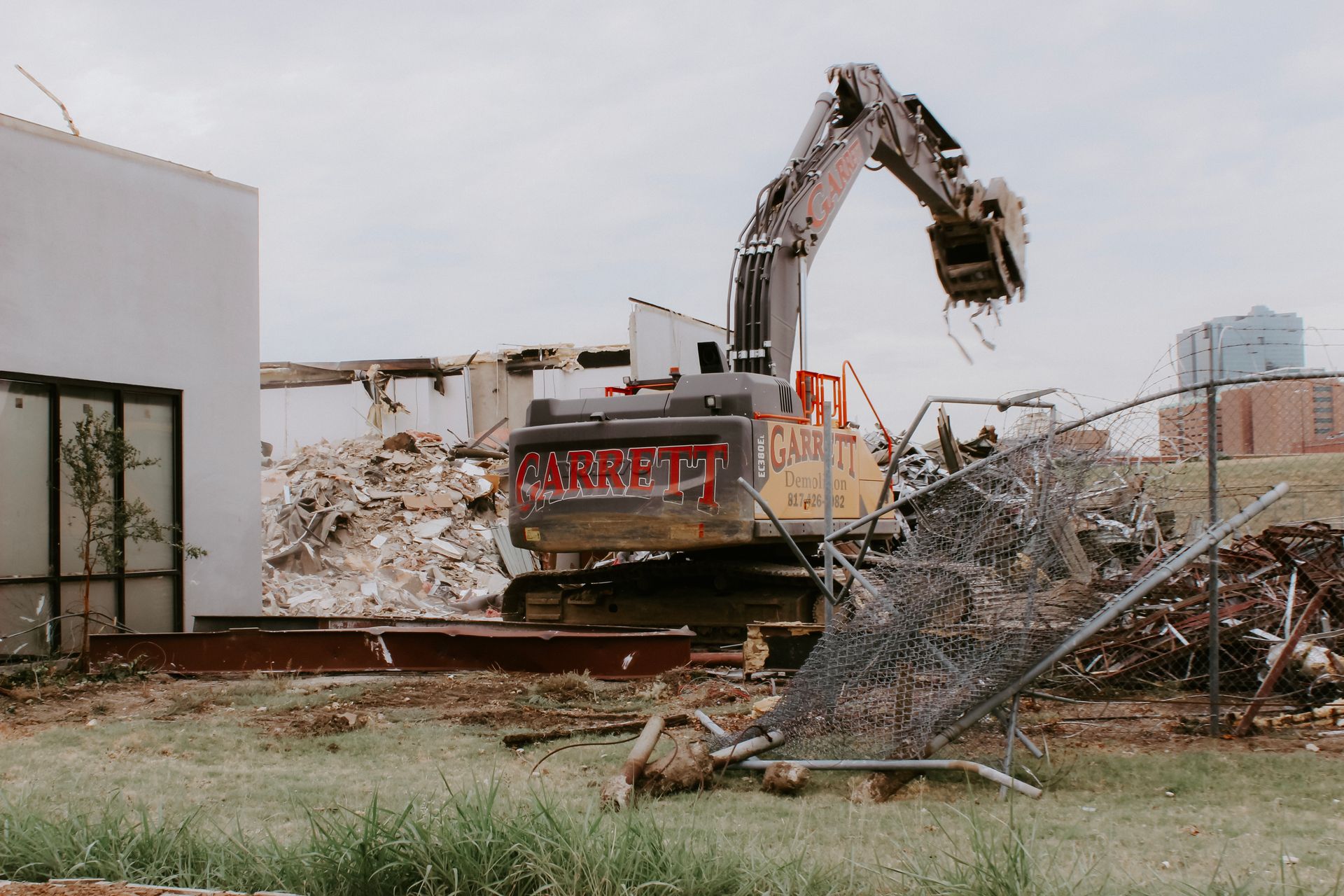 A bulldozer is demolishing a building with the word correct written on it
