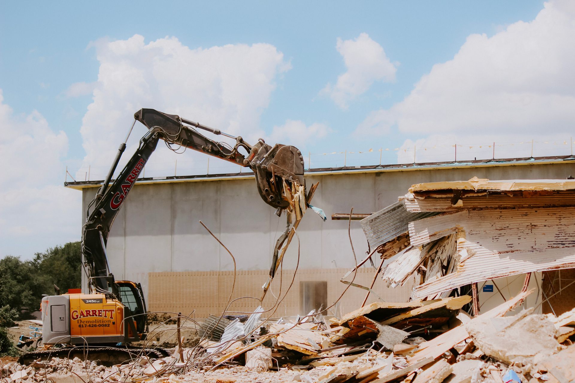 A large excavator is demolishing a building.