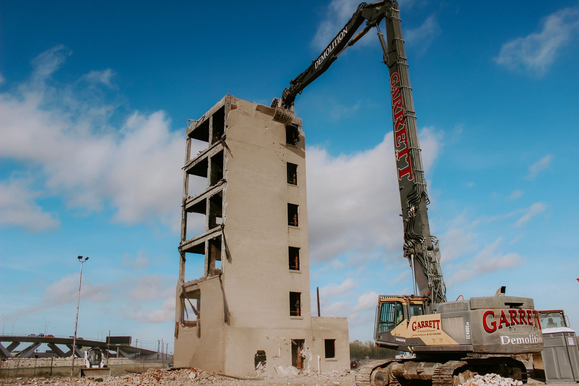 A large building is being demolished by a crane that says gatt
