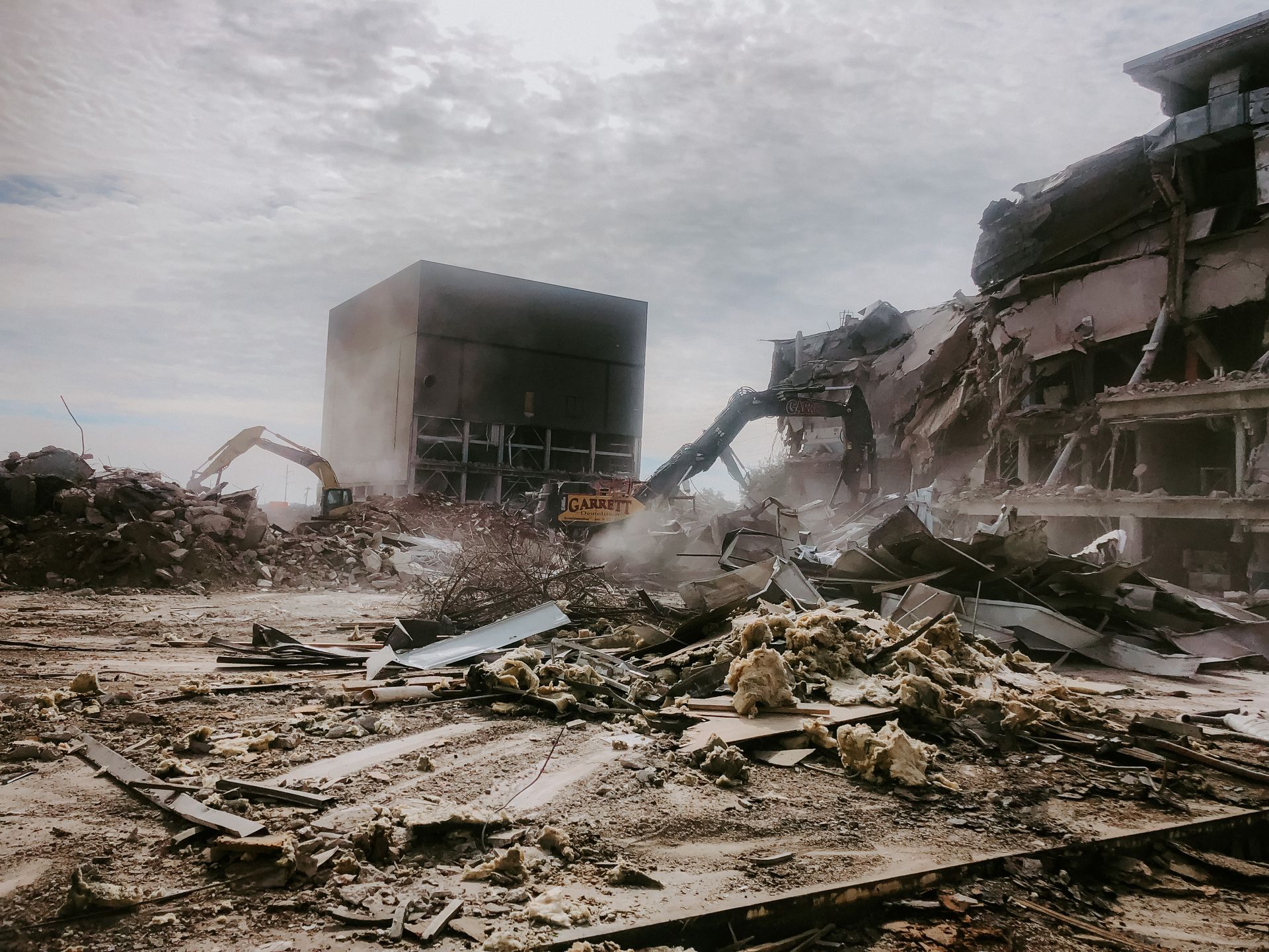 A large building is being demolished by a bulldozer.