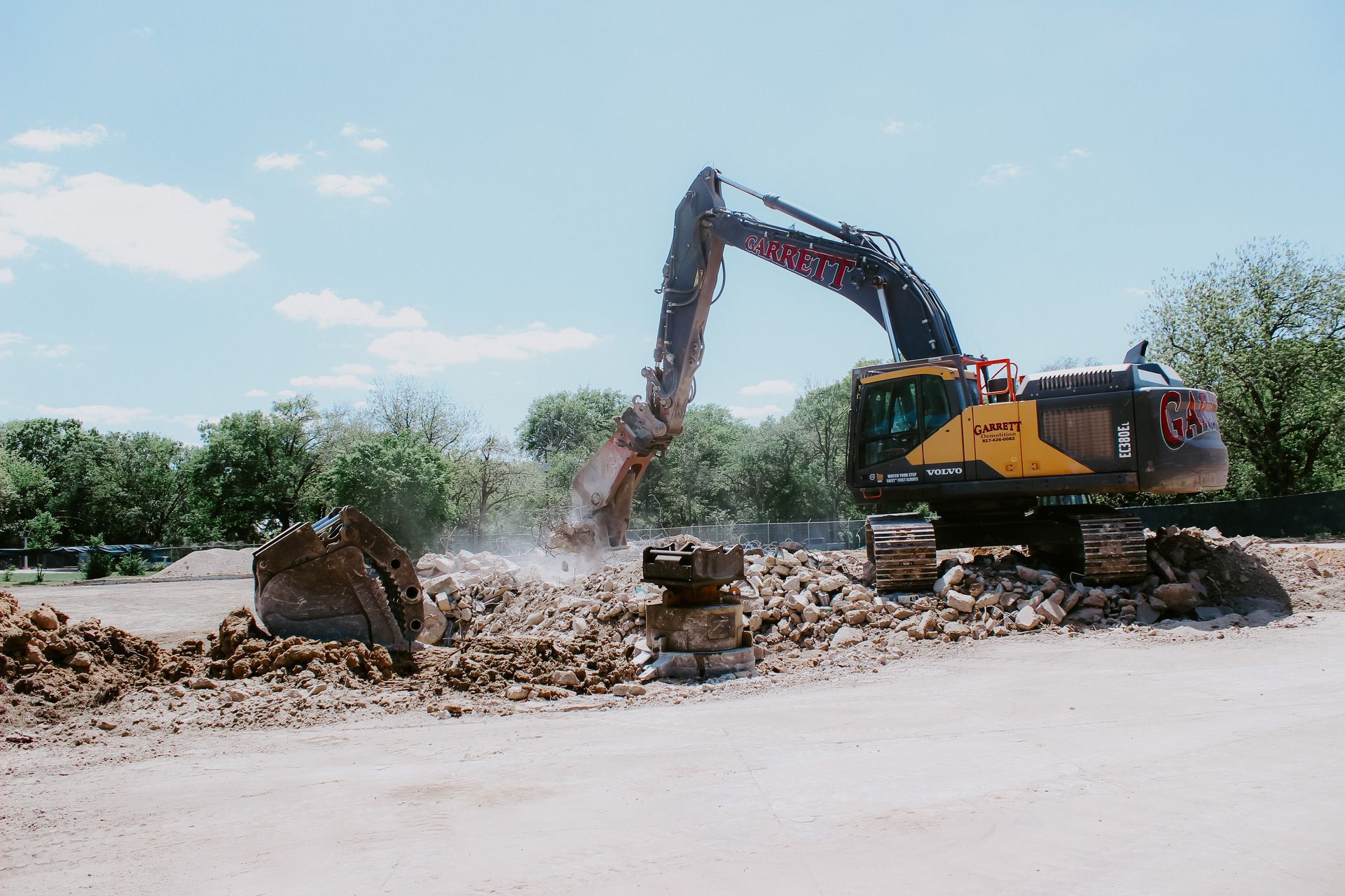 a large excavator is digging a hole in a dirt field .