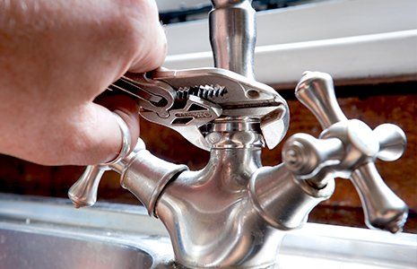 Bad Smell —Close-up of Plumber Using Wrench to Fix Faucet in Griffin, GA