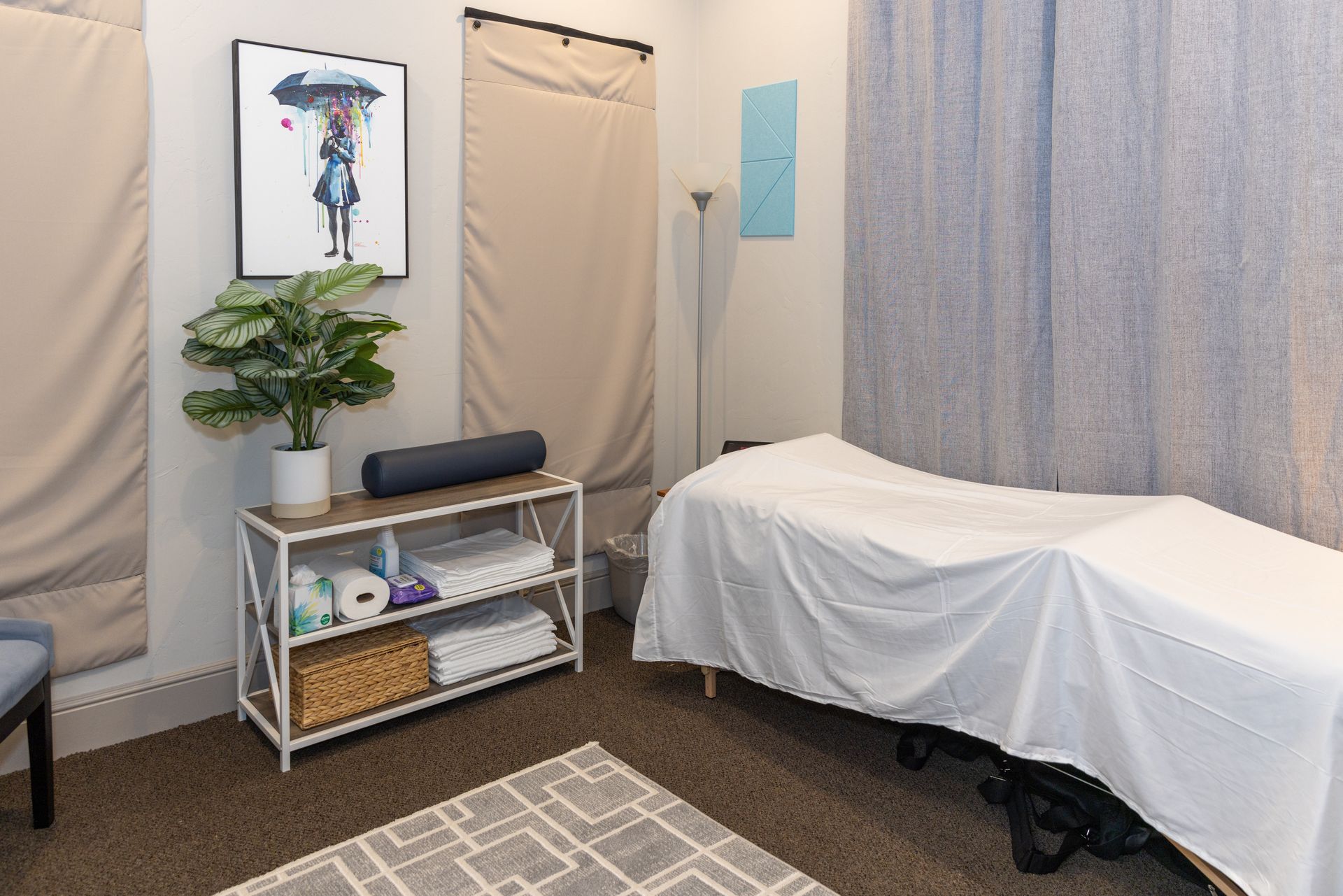 A room with a massage table and a picture on the wall.
