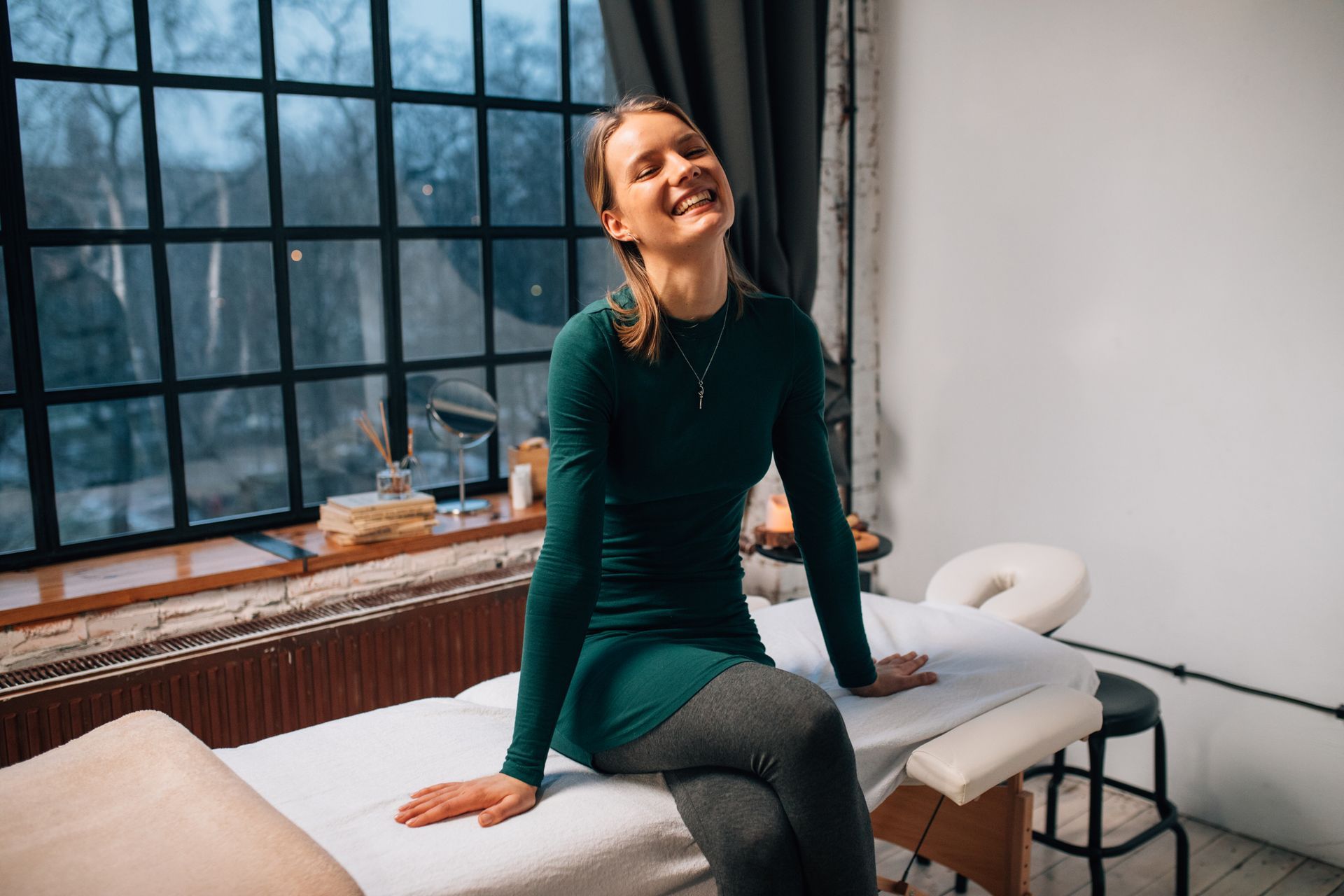 a woman is sitting on a vibroacoustic table receiving Vibroacoustic Sound Therapy in DFW.