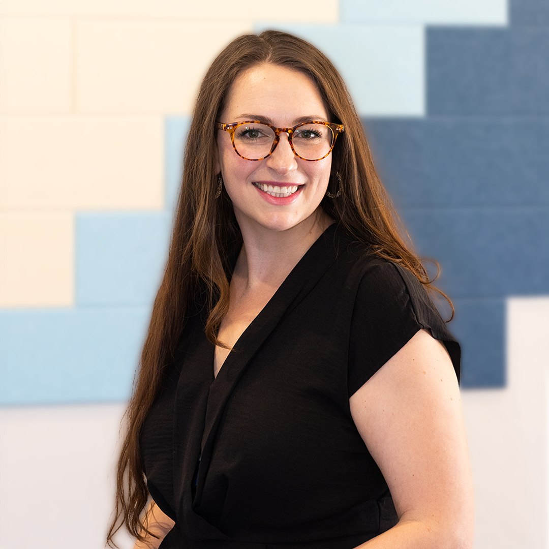 a woman wearing glasses and a black shirt is smiling and providing Brainspotting therapy for perinatal counseling in Grapevine Texas.
