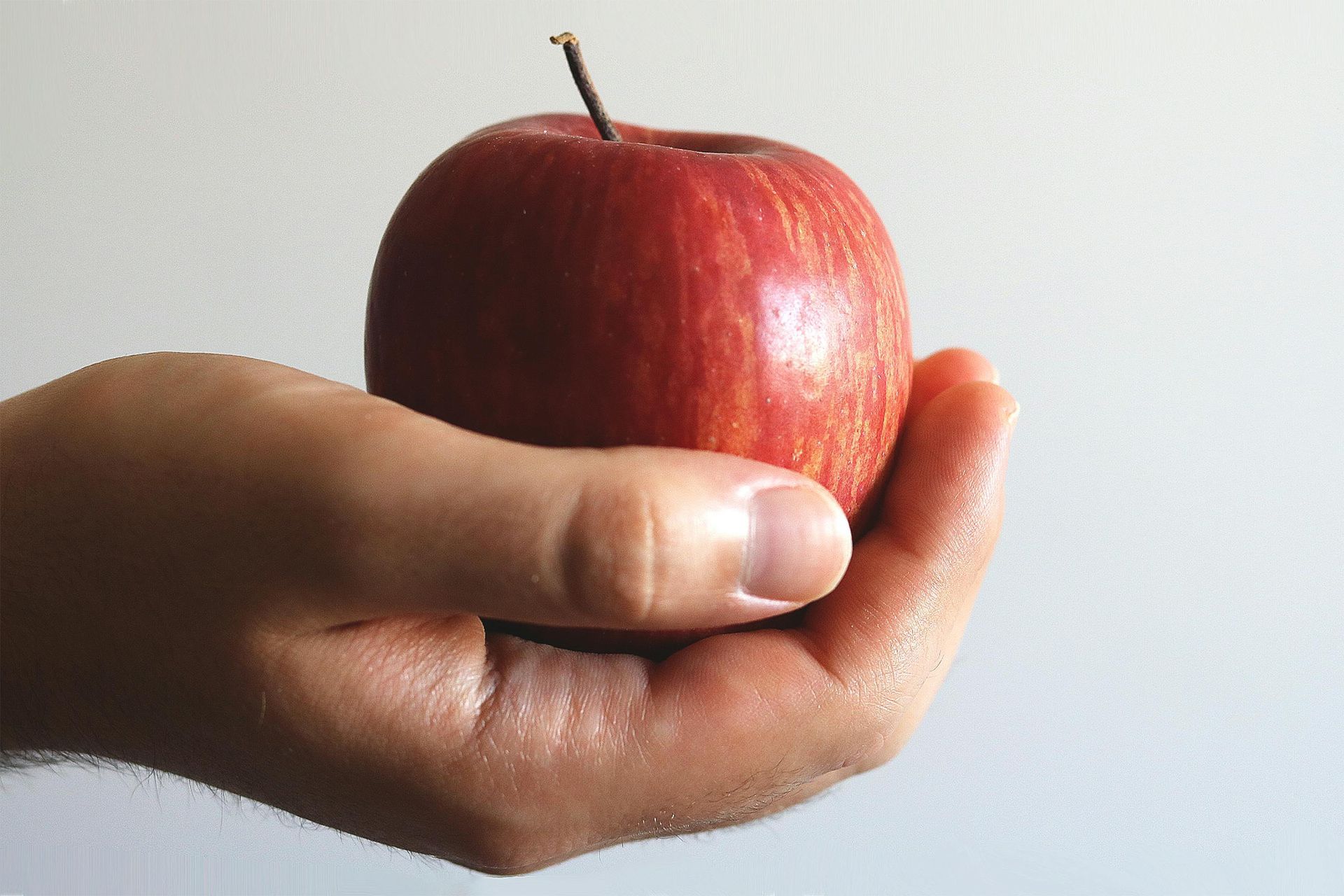 hand holding an apple representing teachers who are burnt out and needing a therapist intensive