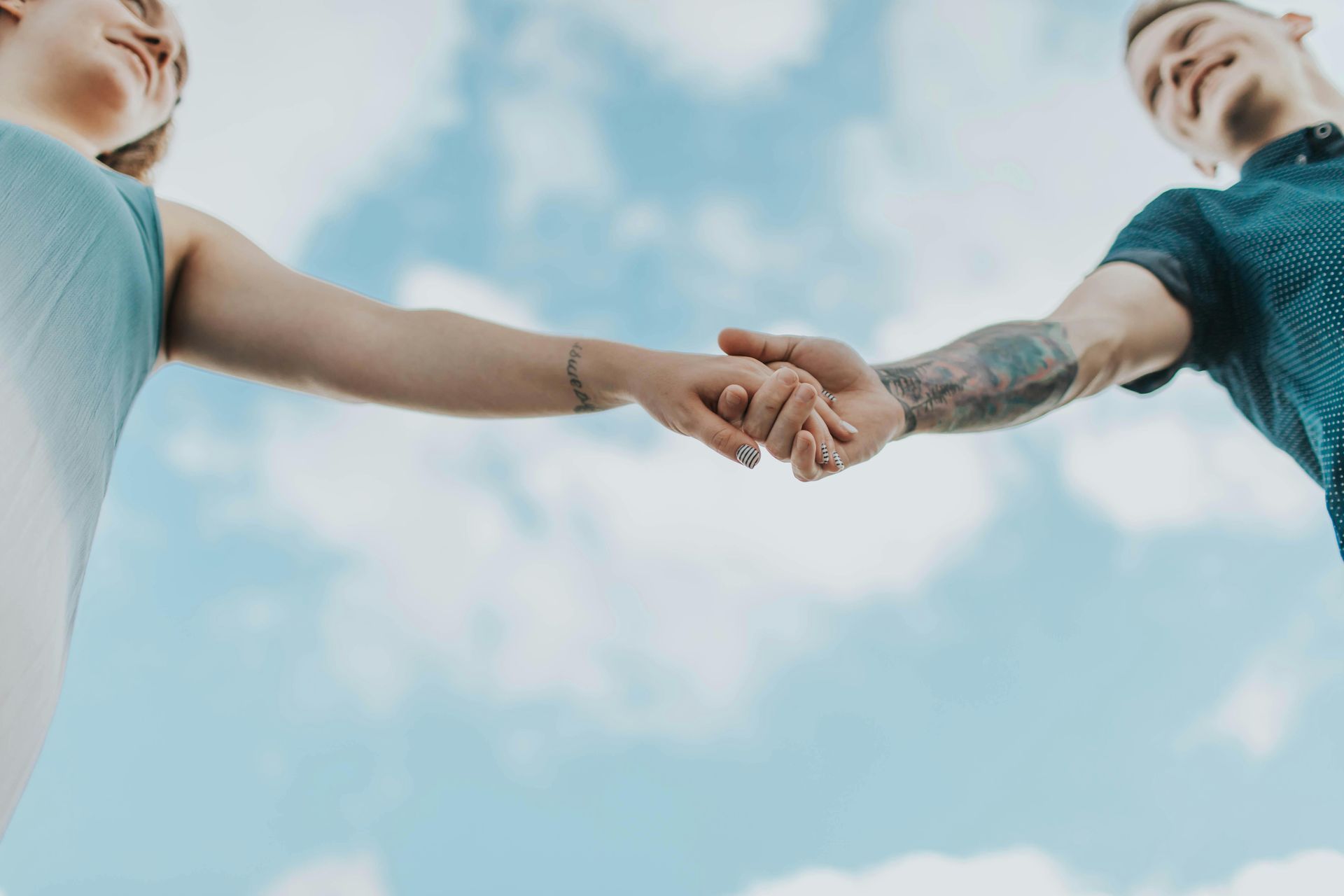 A man and a woman are holding hands in front of a blue sky in Grapevine Texas connecting 