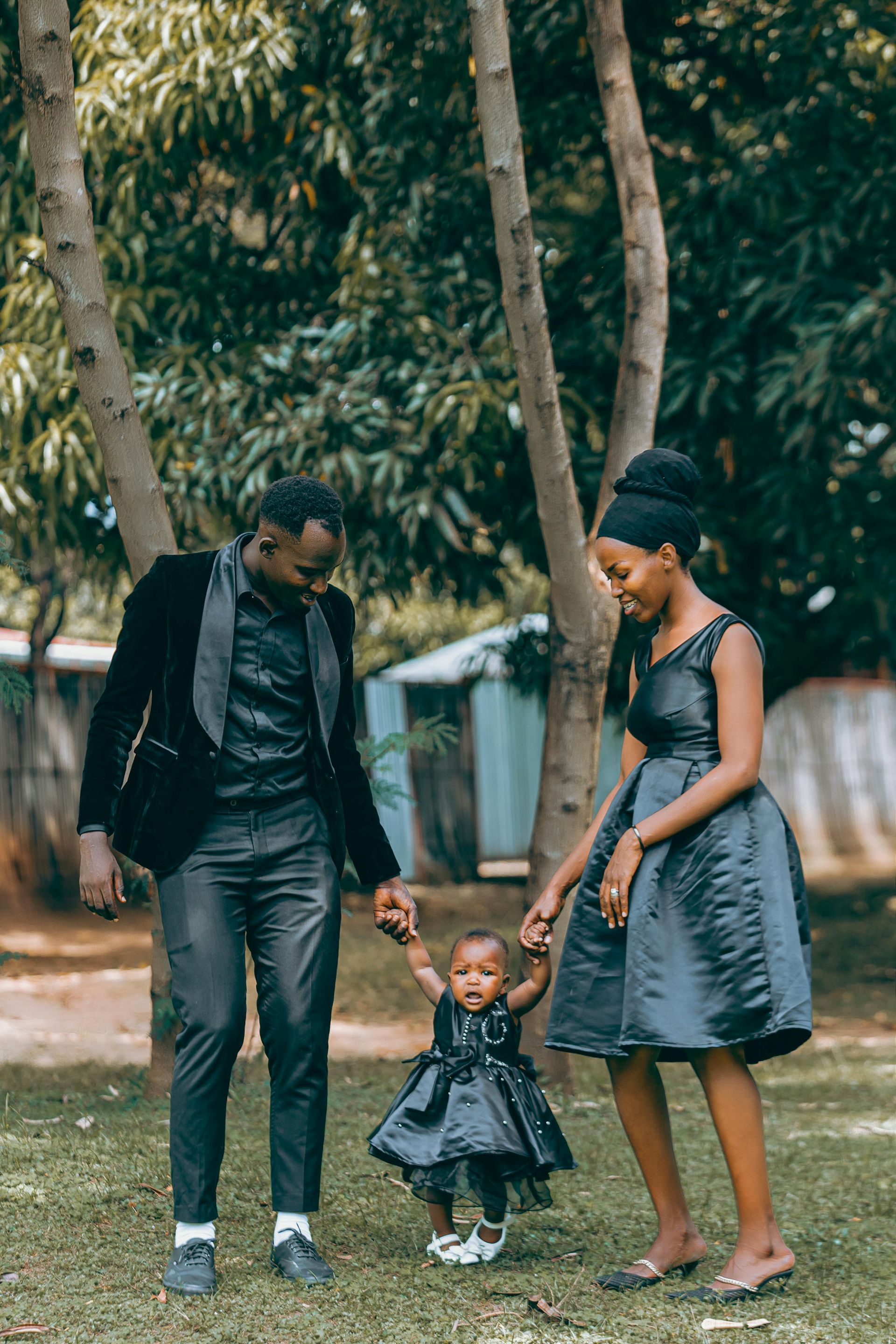 A man and woman are holding hands with a little girl in a park working on co-parenting Grapevine TX