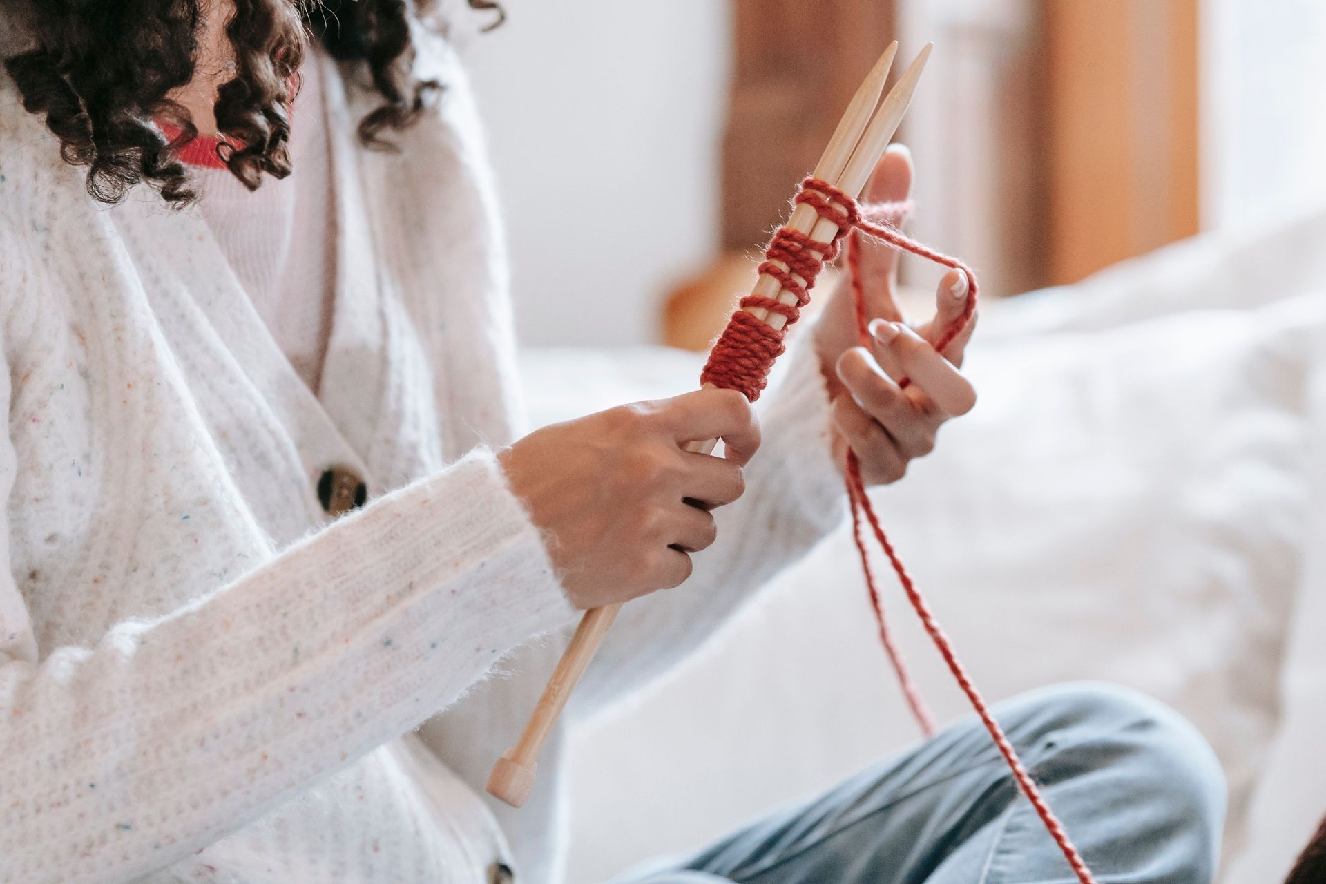 Person knitting while seated on a bed for bilateral stimulation
