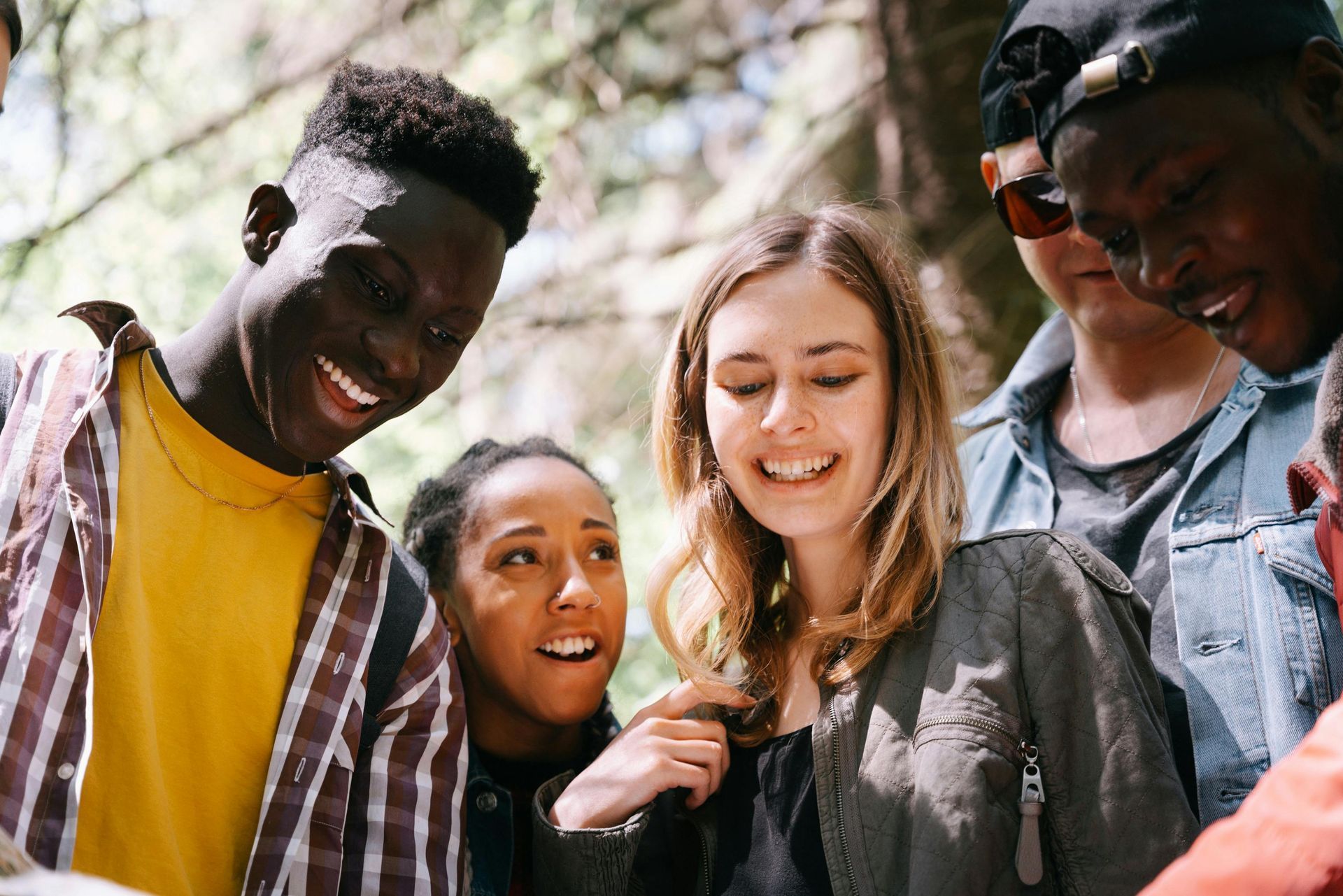 A group of young people are standing next to each other and smiling after going to therapy for teens in DFW.