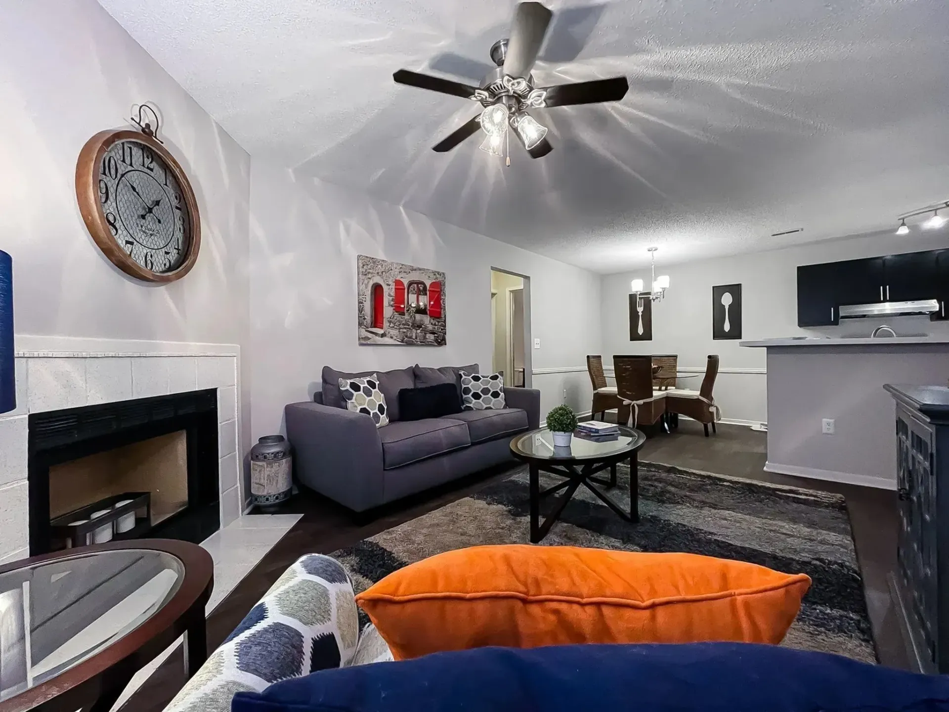 Cozy living room with a grey sofa, side table, and dining area at Plantation Flats in North Charleston, SC.