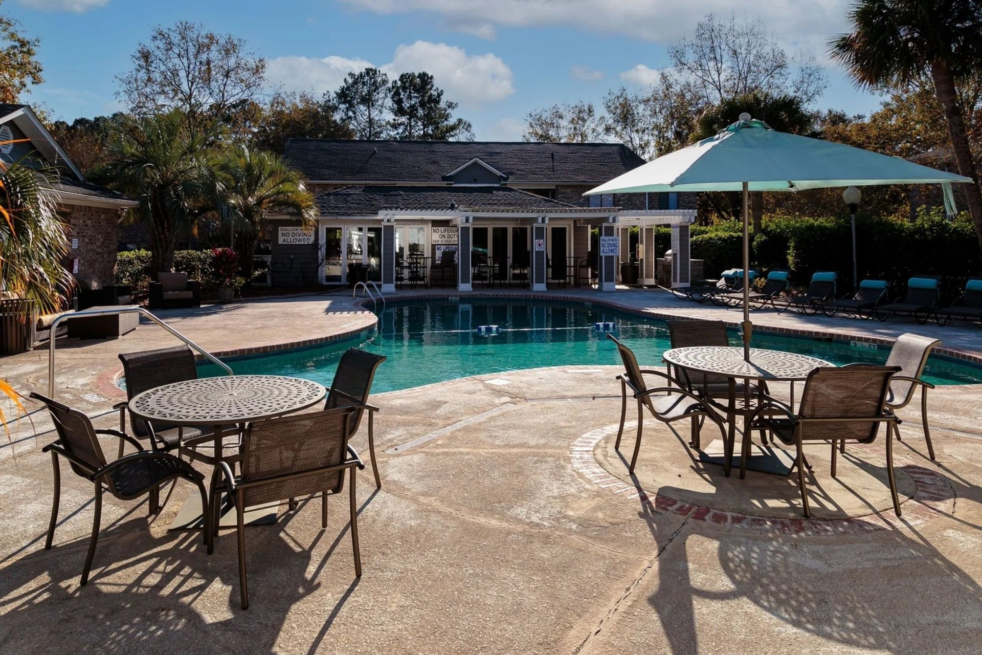 Outdoor community pool area with tables and chairs at Plantation Flats in North Charleston, SC.