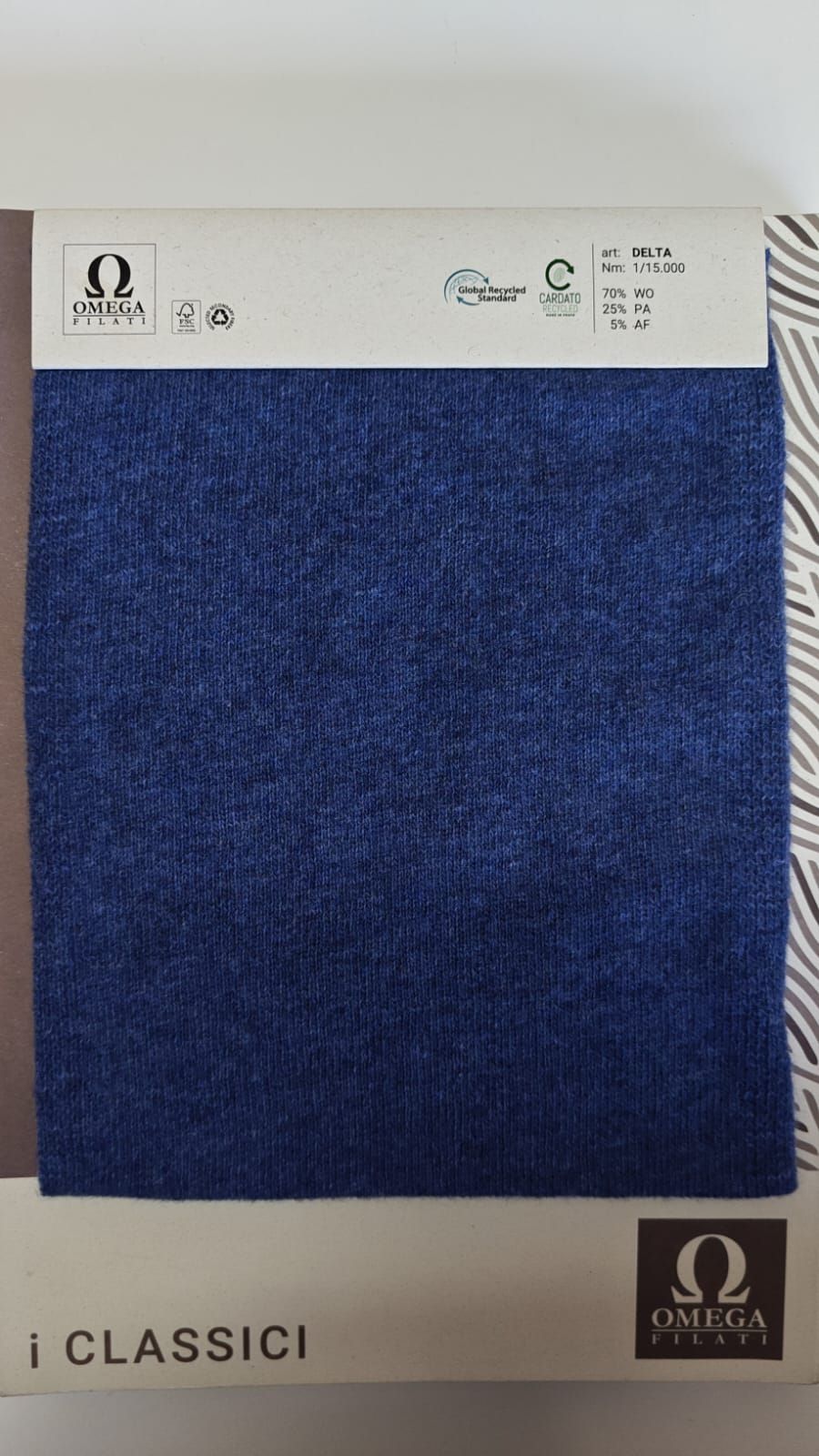 Muestra de tela azul con etiqueta blanca, la marca es 