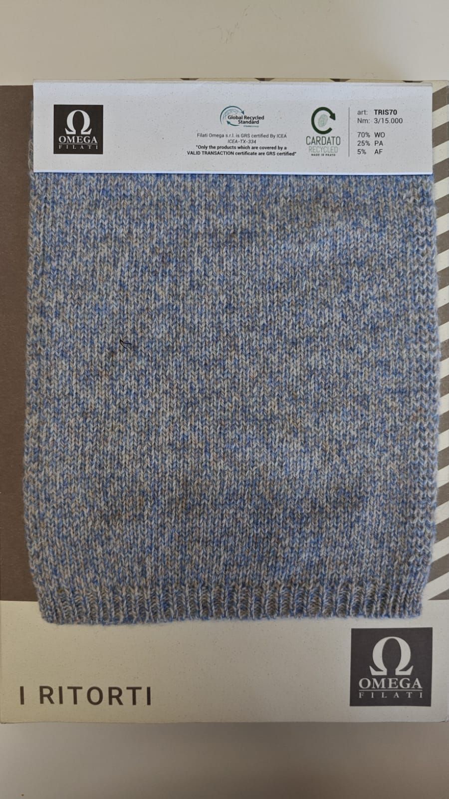 Muestra de tela con textura de punto en azul claro y gris.