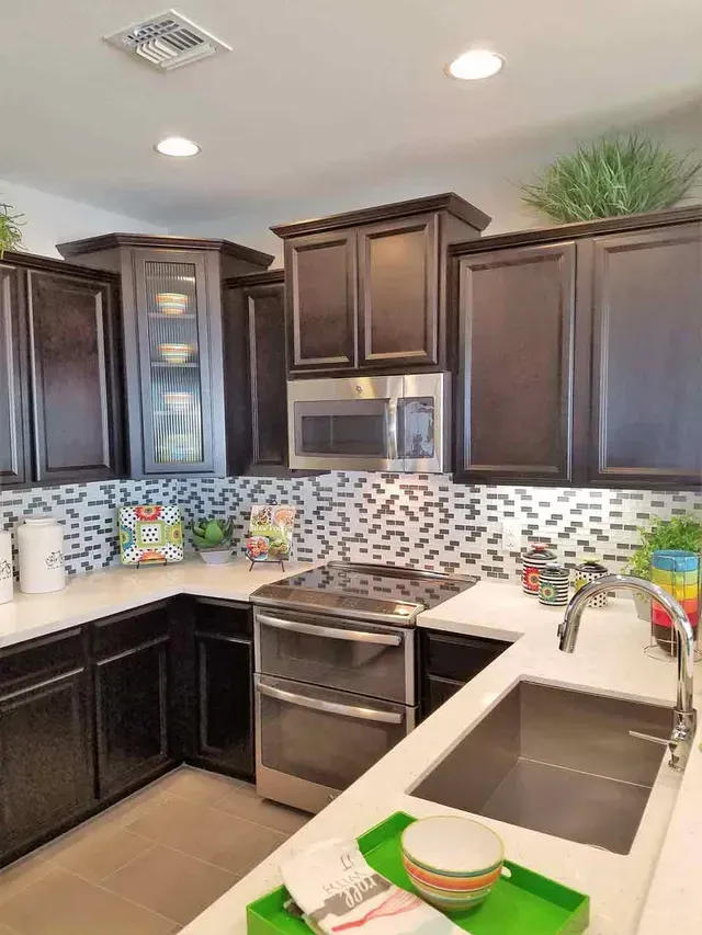 A kitchen with stainless steel appliances , a stove , a sink , and a microwave.