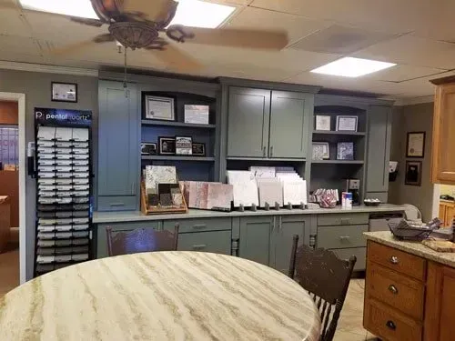 A kitchen with a table and chairs and a ceiling fan.