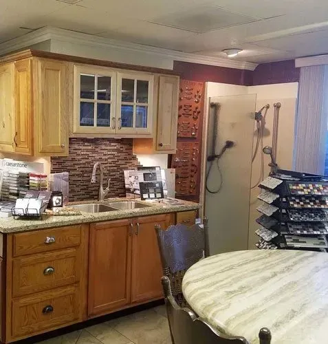 A kitchen with wooden cabinets , a sink , and a round table.