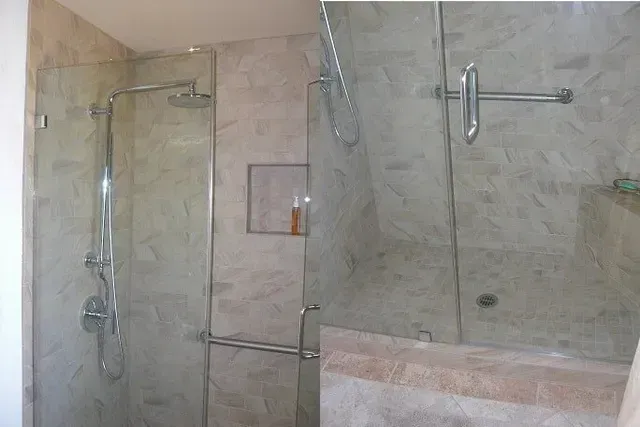 A bathroom with a walk in shower with a glass door.