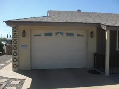 A white garage door is open in front of a house.