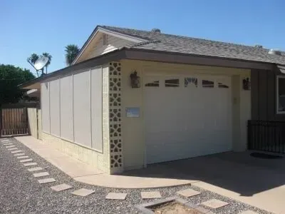 A house with a garage and a walkway leading to it.