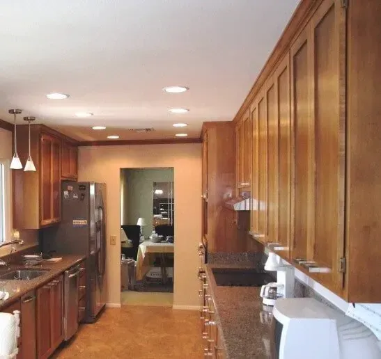 A kitchen with stainless steel appliances and wooden cabinets.