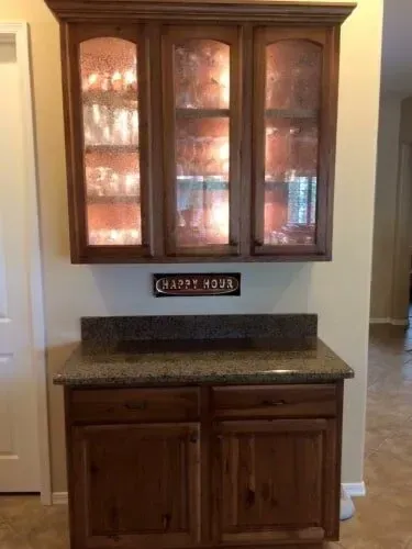 There is a sign on the wall above the cabinets that says happy hour.