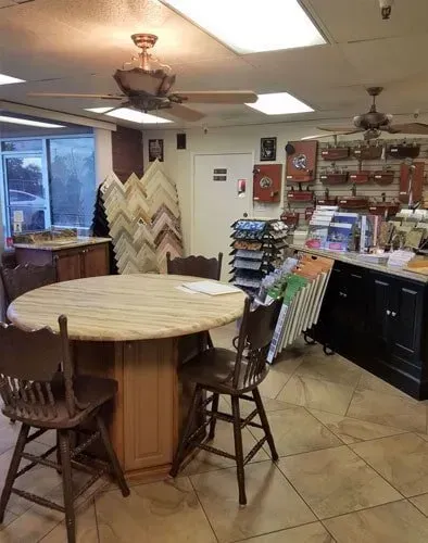 A room with a table and chairs in it and a ceiling fan.