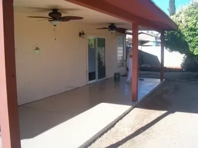 A patio with a ceiling fan and a sliding glass door.