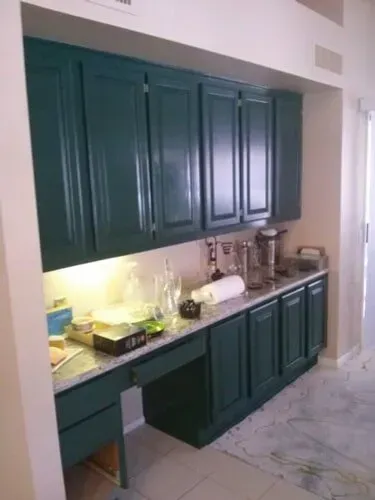 A kitchen with green cabinets