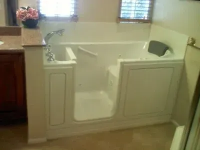 A walk in tub with a door in a bathroom.
