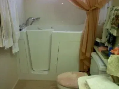 A bathroom with a walk in tub and a toilet.