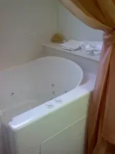 A bathroom with a jacuzzi tub and a shower curtain.