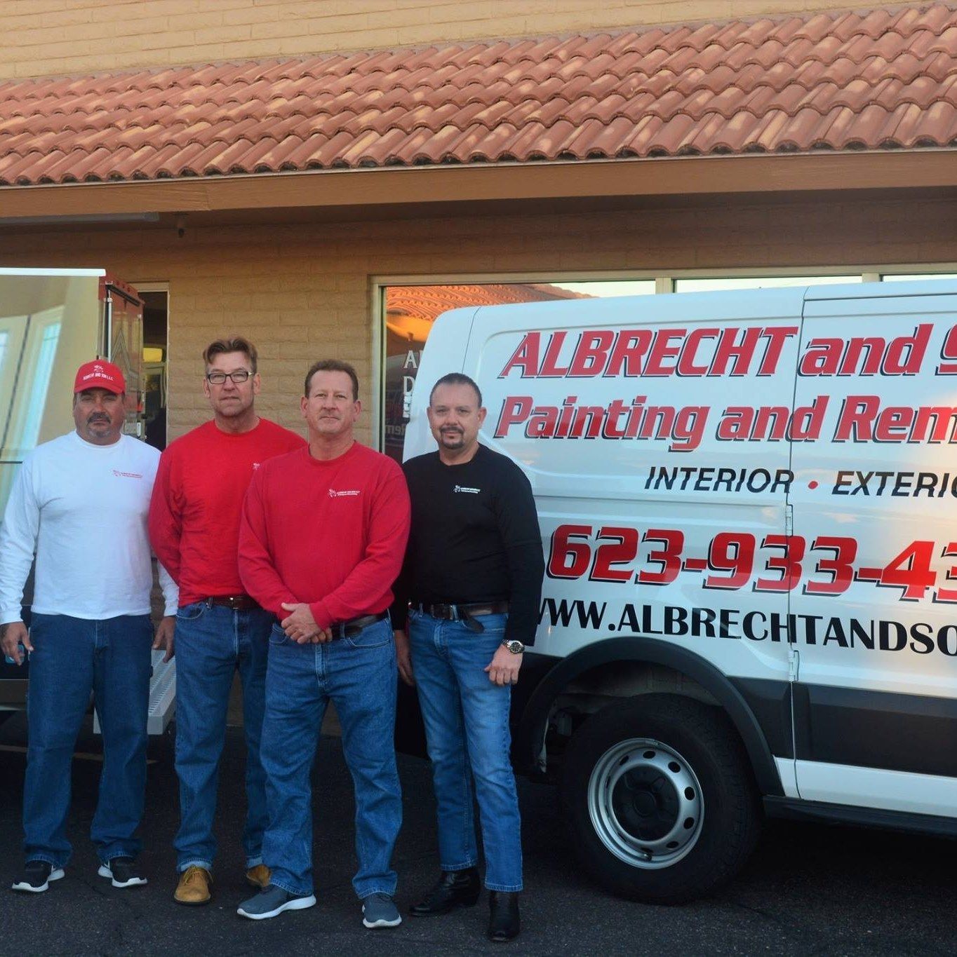 Four men in front of a van that says
