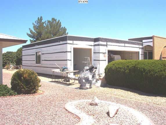 A house with a garage and a statue in front of it.