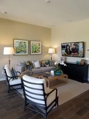A living room with a couch , chairs , coffee table and television.