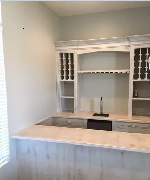 A kitchen with a bar and a wine rack.