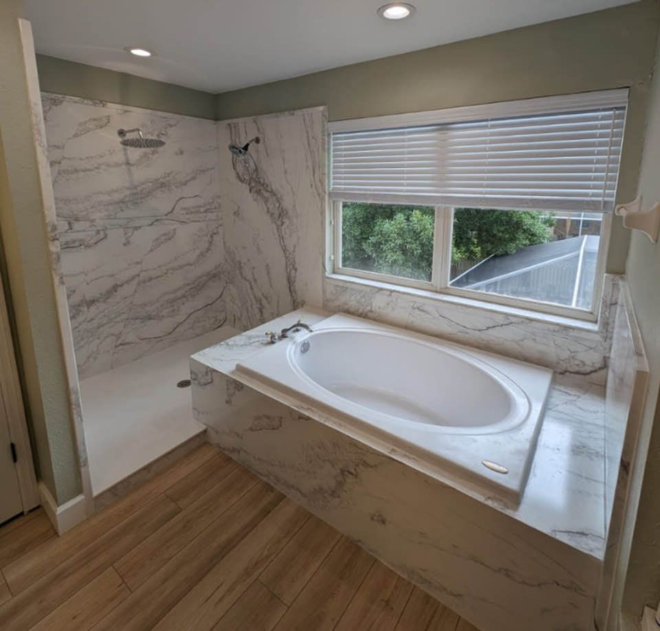 A patio with a couch , table , and umbrella in a garden.