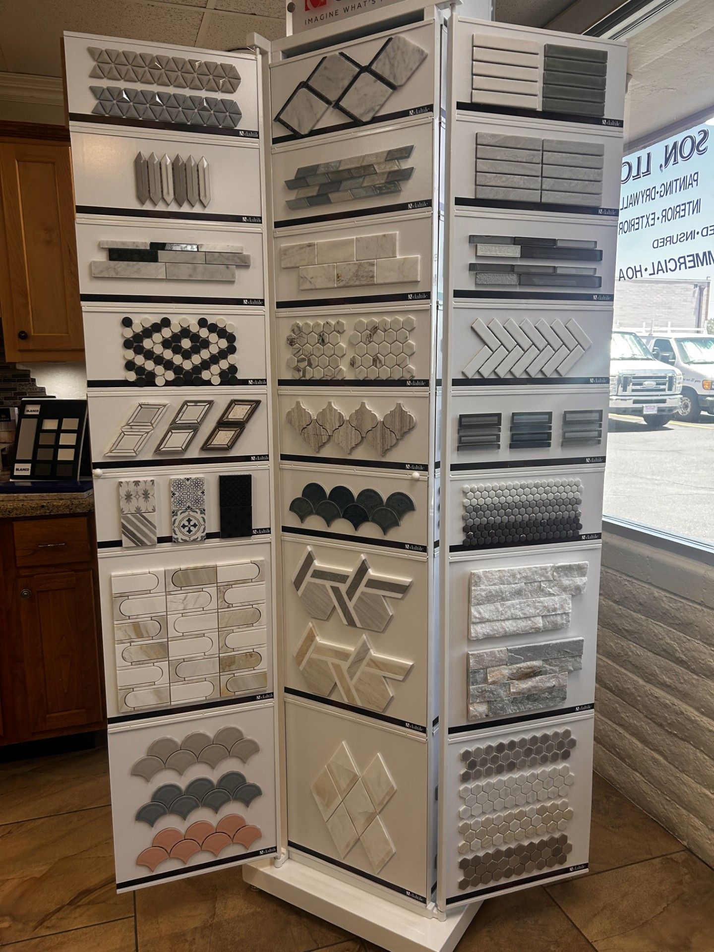 A rotating display showcasing various tile samples, in a showroom setting.