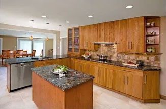 A kitchen with wooden cabinets , granite counter tops , and stainless steel appliances.