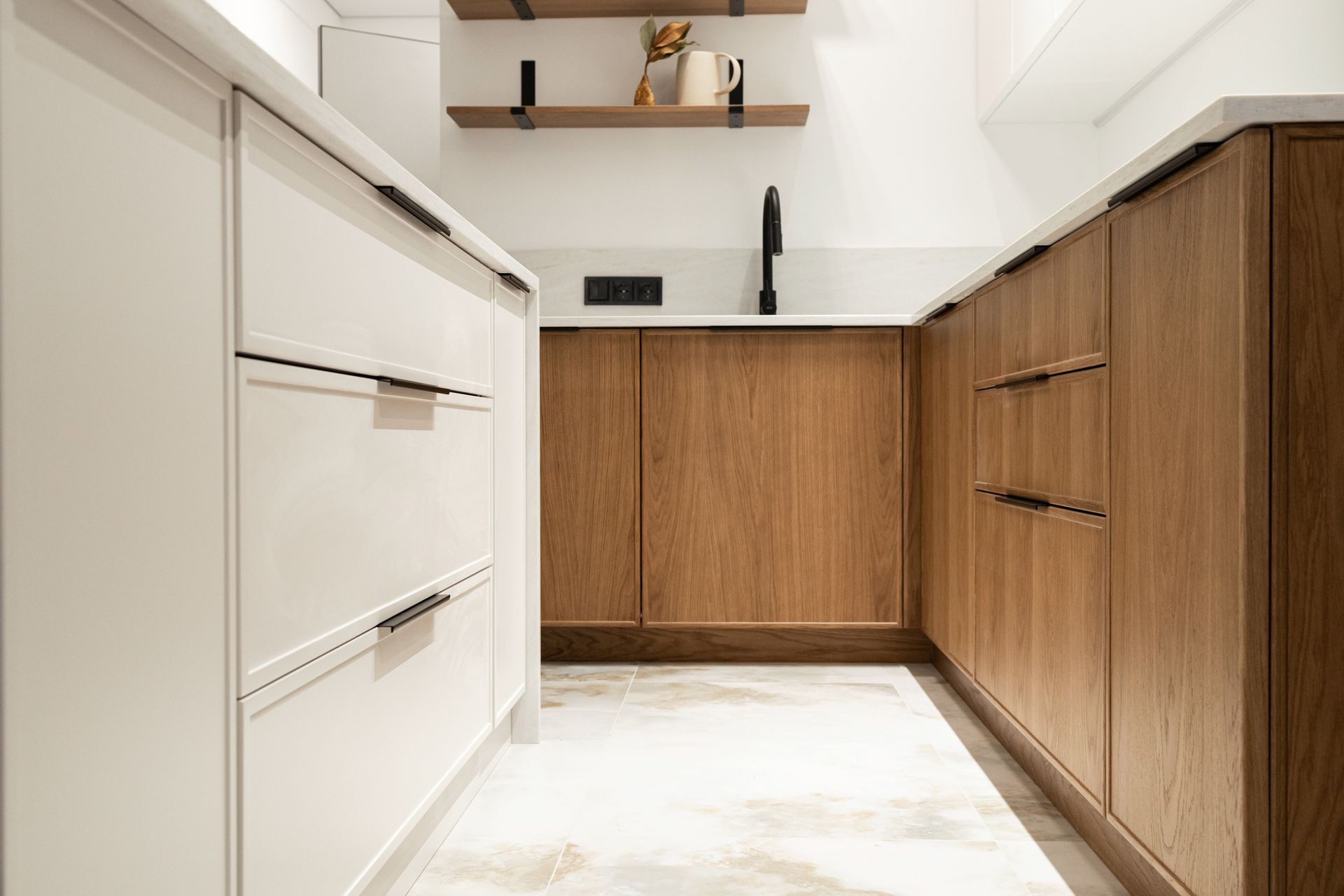 A kitchen with white cabinets and wooden cabinets and a sink.