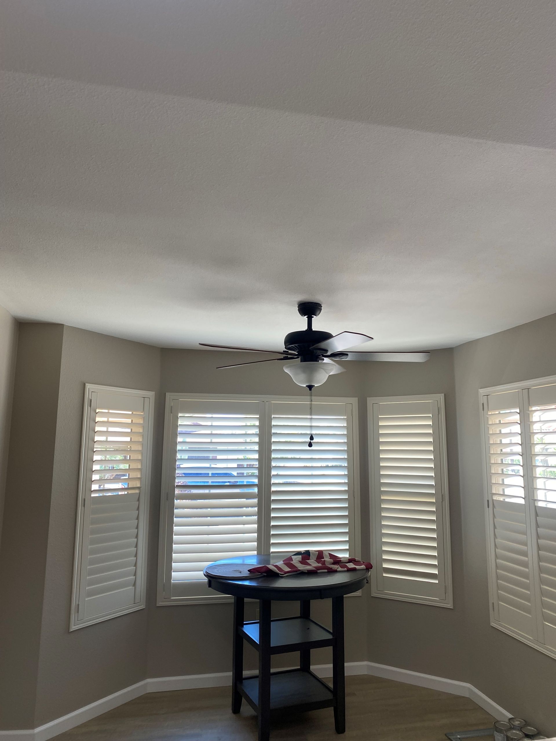 A room with a table and a ceiling fan