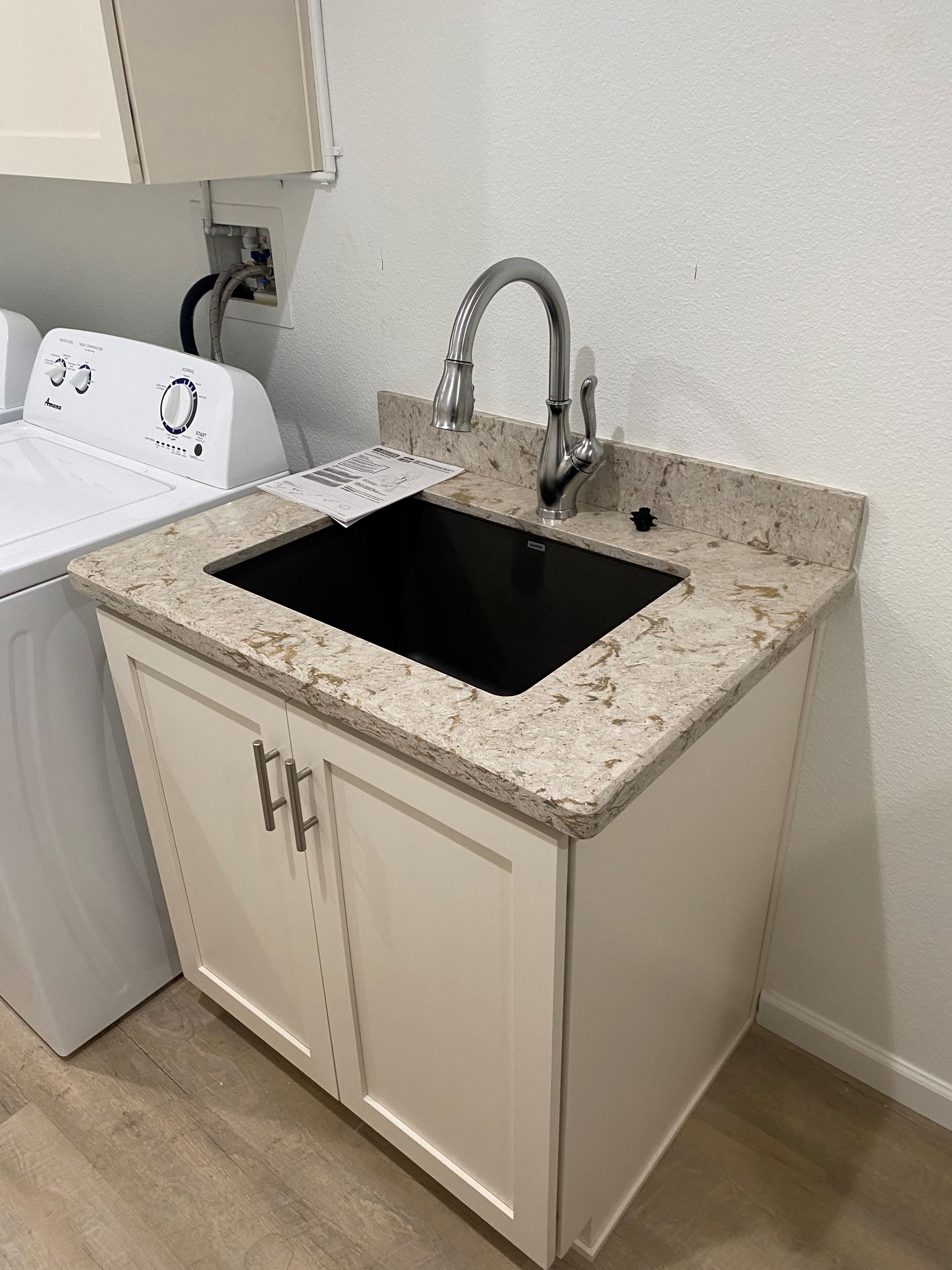 A laundry room with a washer and dryer and a sink.