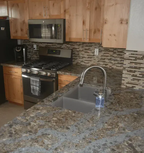 A kitchen with granite counter tops and a sink.