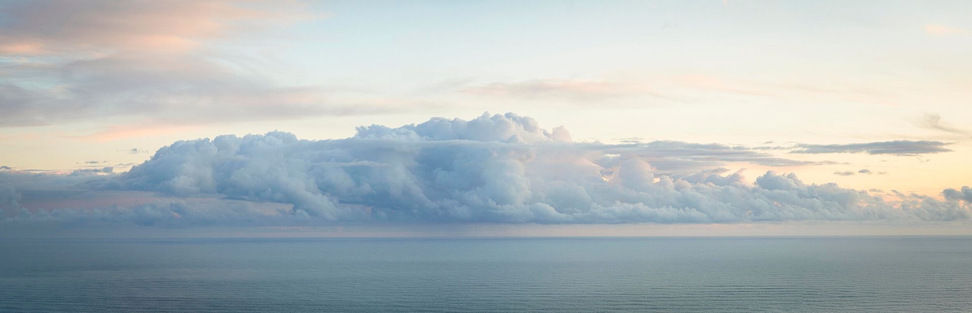A blurry picture of a cloudy sky over a body of water.