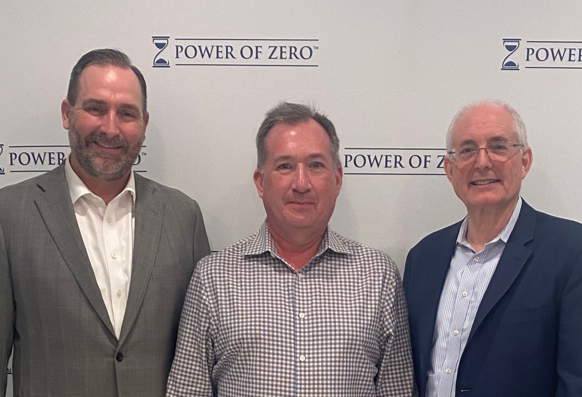 Three men standing in front of a wall with 