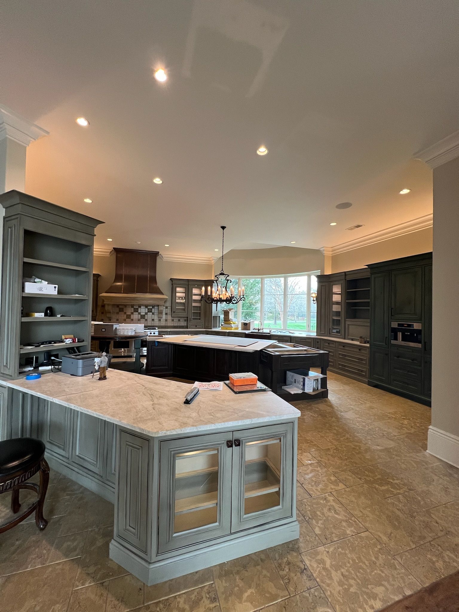 Spacious kitchen with gray cabinets, large island, and light-colored countertops.