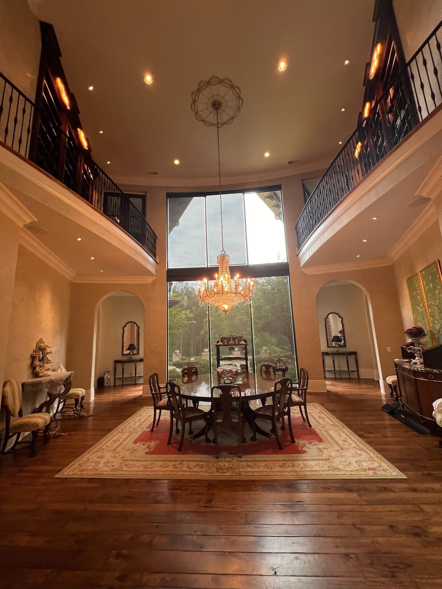 Elegant dining room with chandelier, large windows, and balconies.