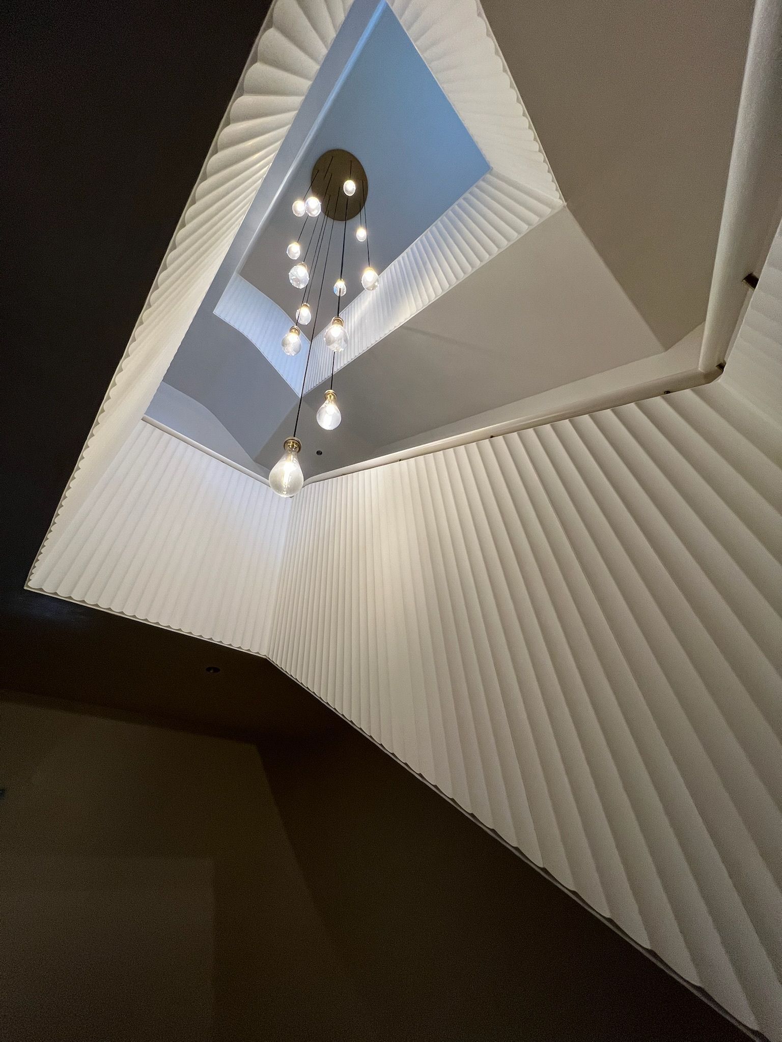 Modern architectural ceiling with a cascading light fixture.